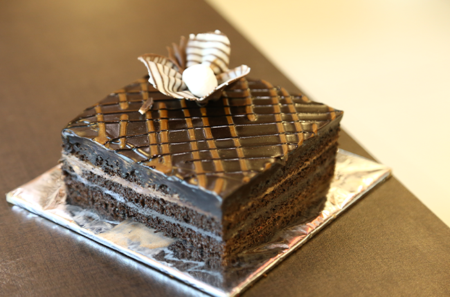 Rich chocolate cake available at a dessert business franchise with affordable cake and bakery franchise options.
